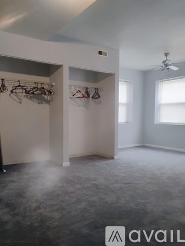 A room with a fan and a wall of hangers.