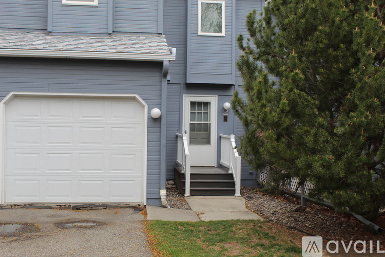 A house with a white garage door and a grey house.