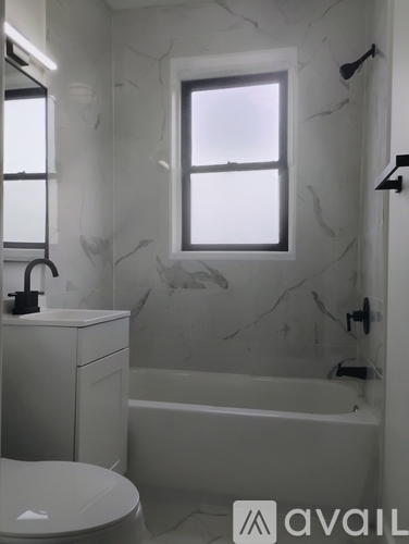 A bathroom with a marble wall and a window.