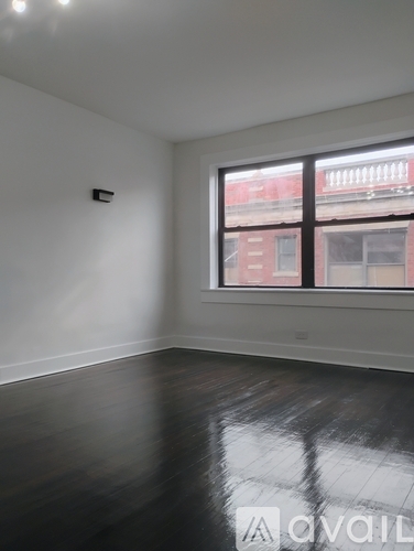 A room with a window and wooden floors.