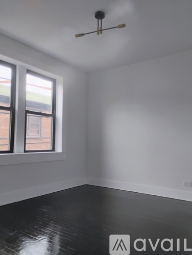 A room with a window and a fan on the ceiling.