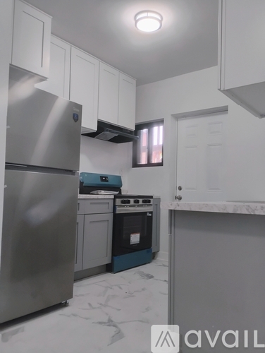 A kitchen with a stainless steel refrigerator and a blue dishwasher.