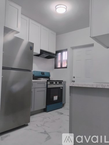 A kitchen with a stainless steel refrigerator and a blue dishwasher.