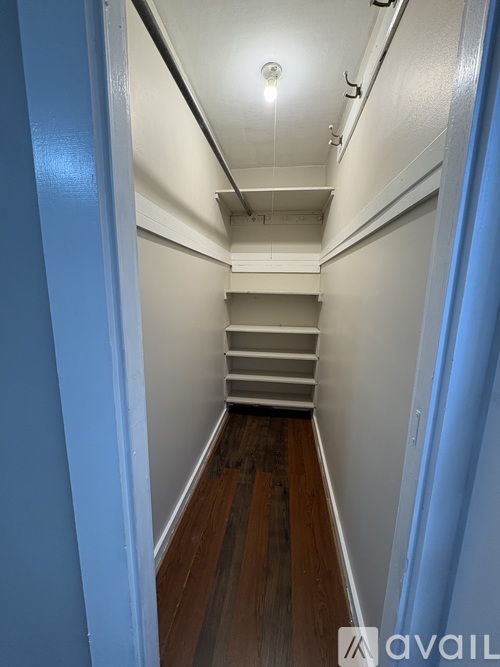 A long hallway with a staircase and a light on the ceiling.