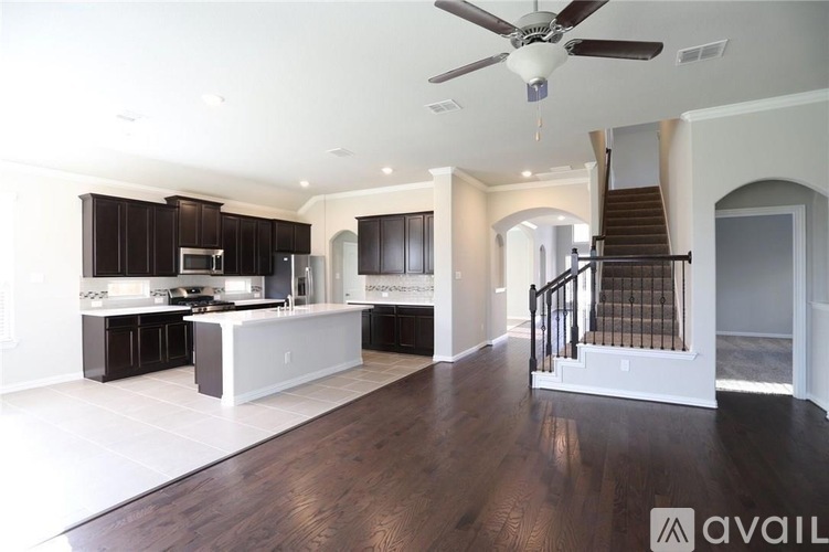 A spacious kitchen with dark wood cabinets and a white island.