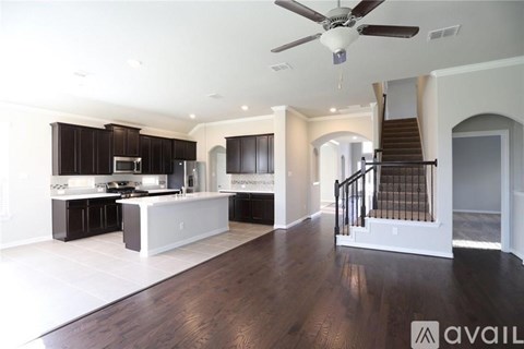 A spacious kitchen with dark wood cabinets and a white island.