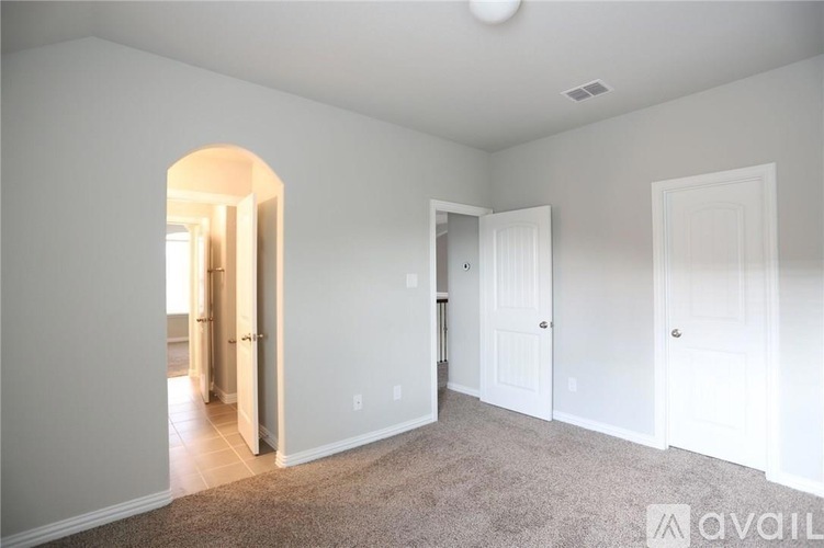 A spacious living room with a carpeted floor and white walls.