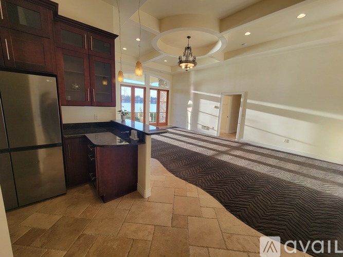 A kitchen with a refrigerator, cabinets, and a countertop.