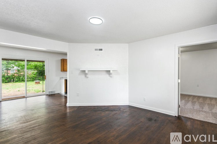A spacious room with wooden floors and white walls.