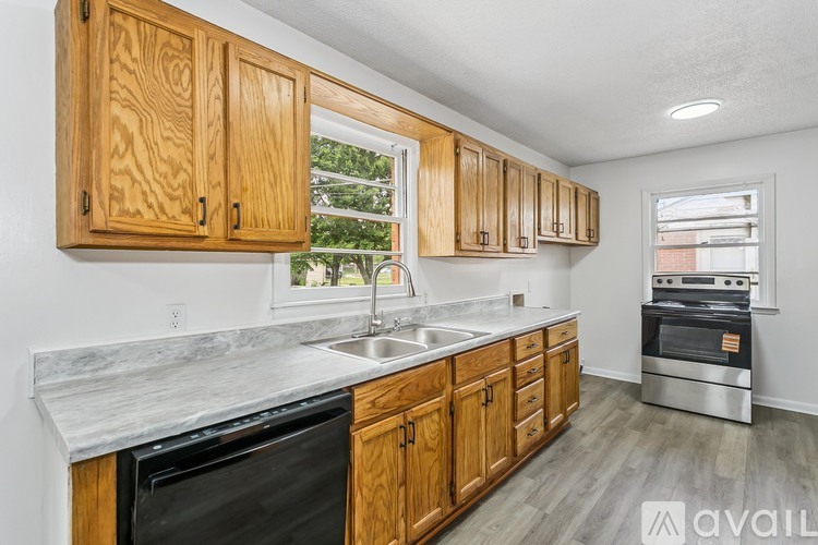 A kitchen with wooden cabinets and a marble countertop.