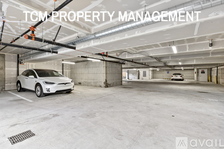 A Tesla car is parked in a spacious parking garage.