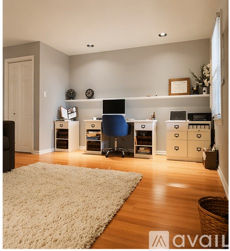A living room with a white rug and a blue chair.