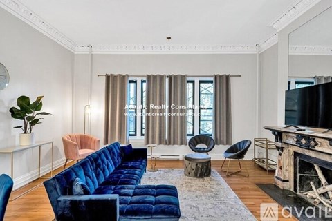 A living room with a blue couch and a fireplace.
