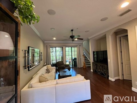 A living room with a white couch and a ceiling fan.