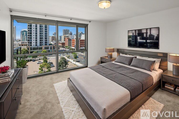 A bedroom with a large bed and a view of the city.