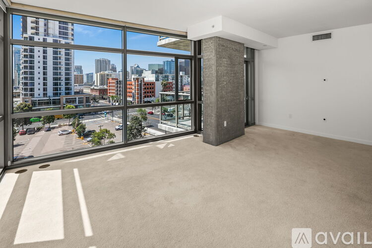 A spacious room with a large window overlooking a city street.