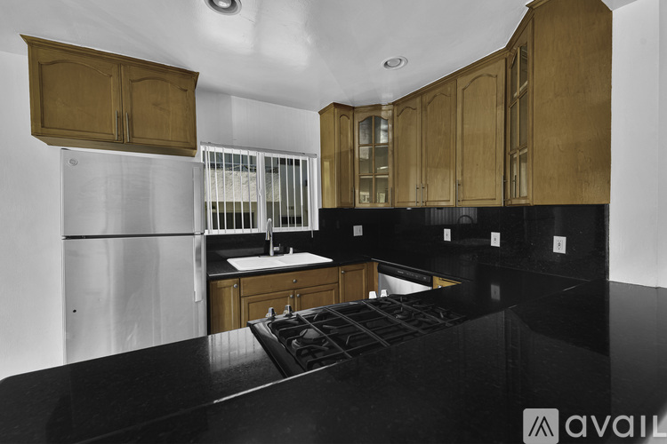 A kitchen with wooden cabinets and a black countertop.