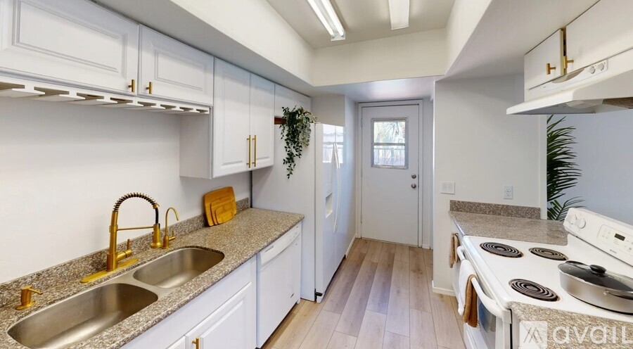 A kitchen with white cabinets and a granite countertop.