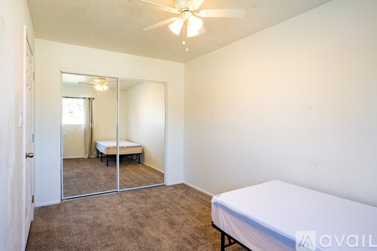 A bedroom with a bed, mirror, and carpet.