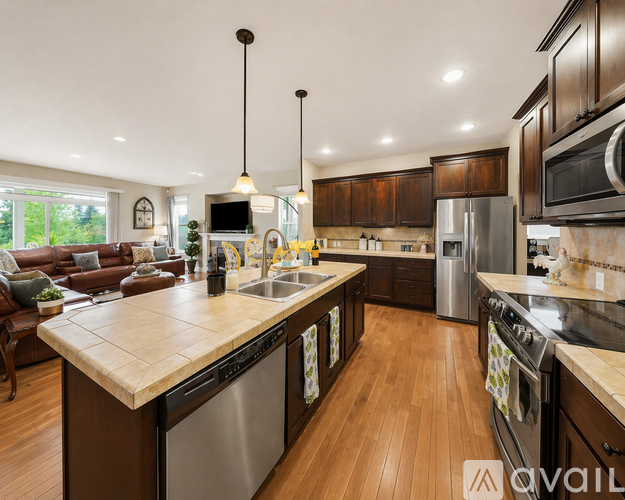 A modern kitchen with dark wood cabinets and stainless steel appliances.