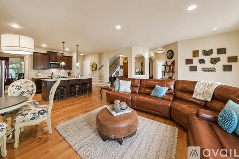 A living room with a brown leather couch and a round coffee table.