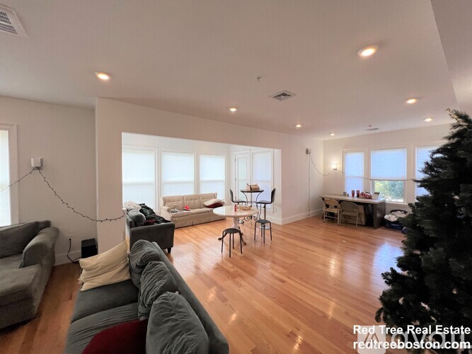 A living room with a grey couch and a wooden floor.