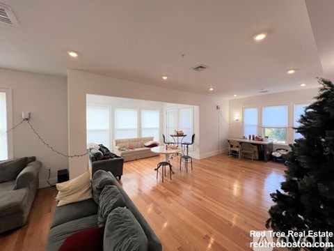 A living room with a grey couch and a wooden floor.