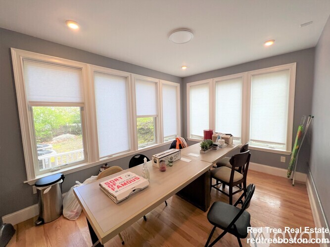A dining room with a table and chairs and a window.