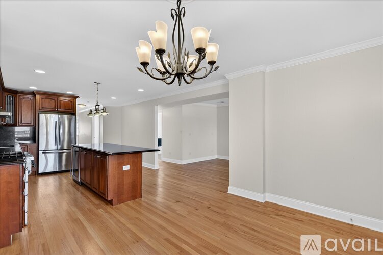 A kitchen with wooden cabinets and a chandelier.