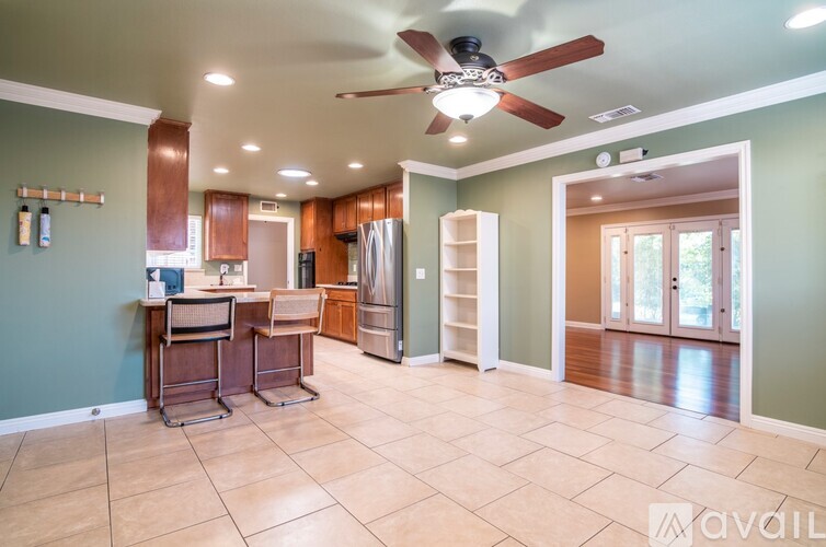 A kitchen with a bar stool and a fan.