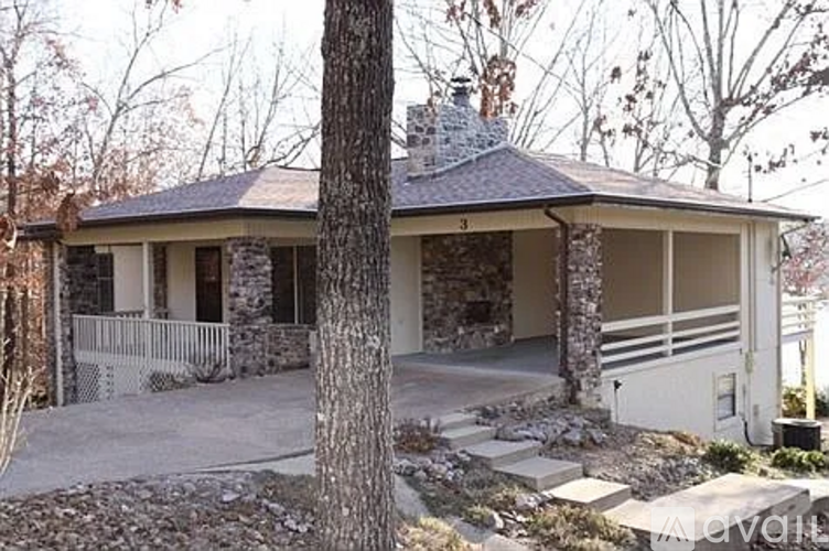A house with a stone chimney and a porch.