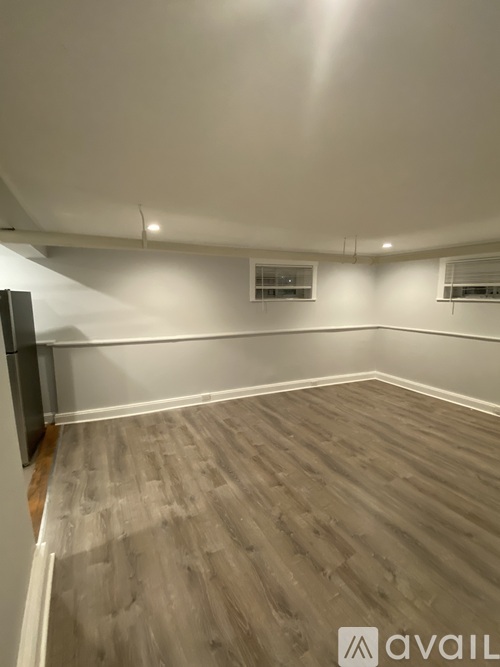A room with wooden flooring and white walls.