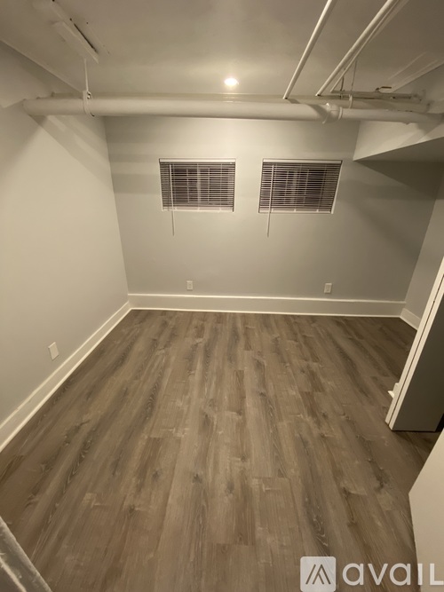 A room with wooden flooring and white walls.