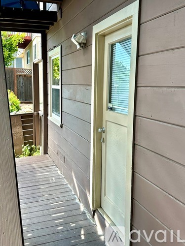 A wooden deck with a white door and window.
