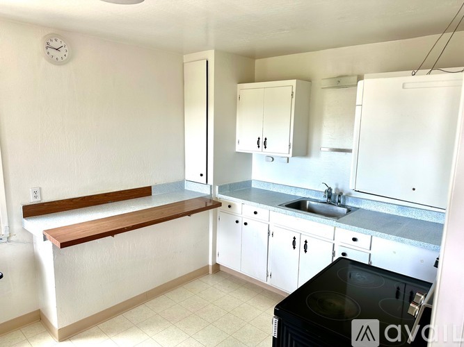 A kitchen with white cabinets and a black stove top.