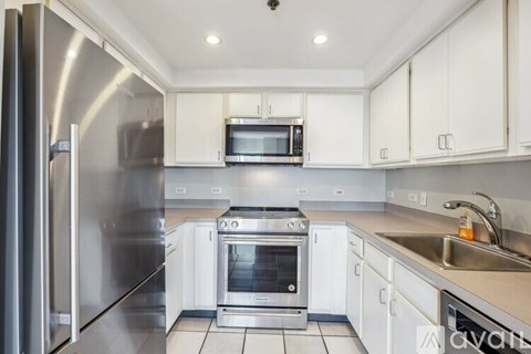 A kitchen with white cabinets and stainless steel appliances.