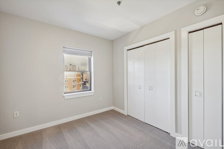 A room with a window, a door, and a carpeted floor.