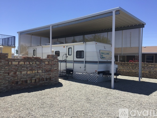 A mobile home is parked under a covered patio.
