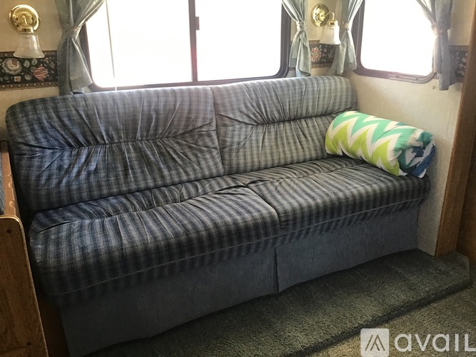 A blue and white checkered couch with a striped pillow on it.