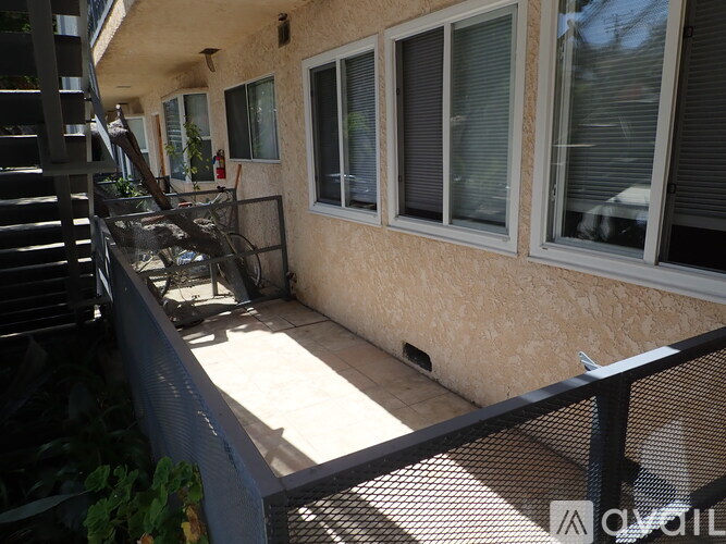 A patio with a table and chairs is on the balcony of a house.