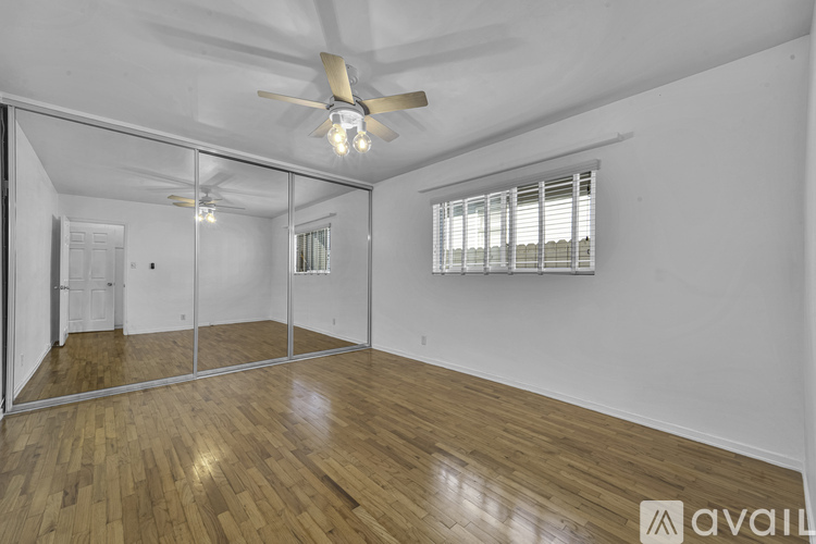 A room with wooden flooring and a ceiling fan.