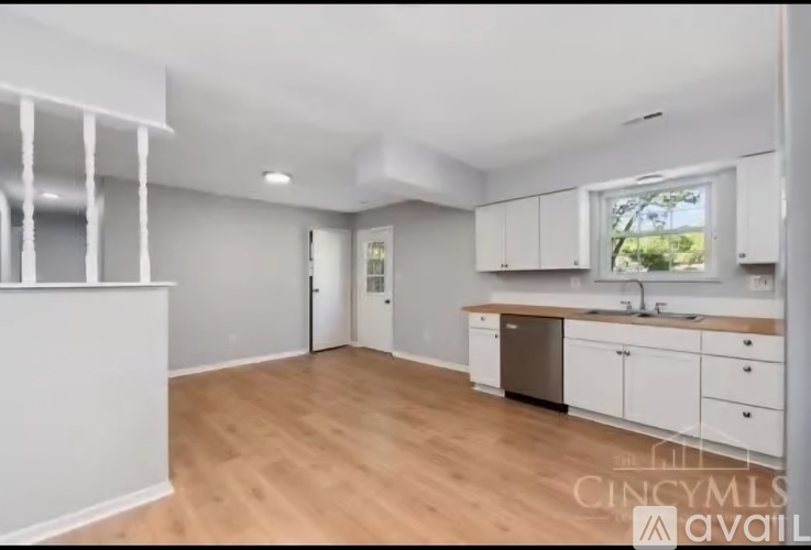 A kitchen with white cabinets and a window.