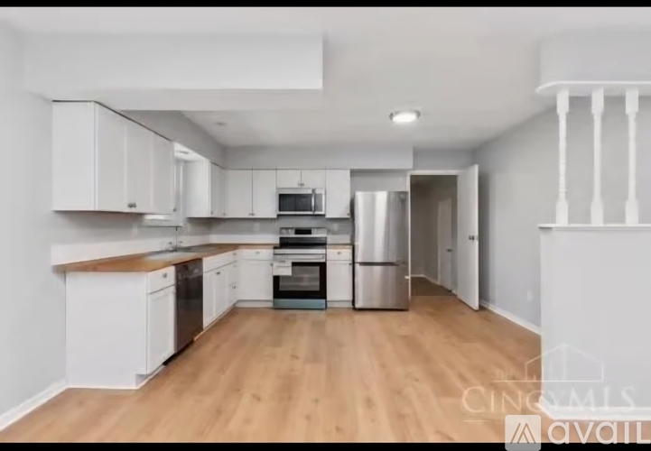 A kitchen with white cabinets and a wooden counter top.