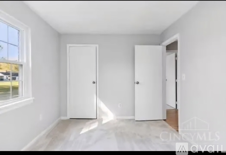 A white room with two doors and a window.
