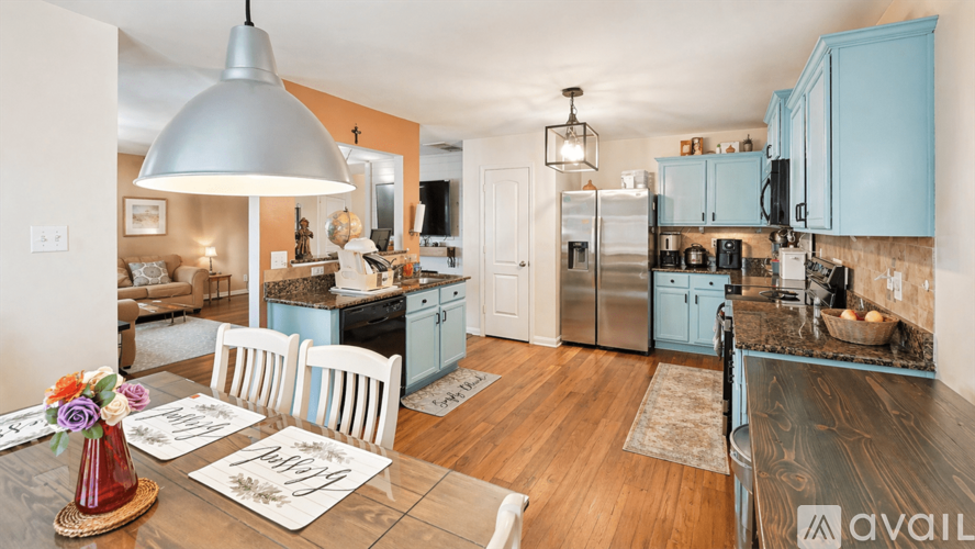 A kitchen with a table set for two and a dining area.