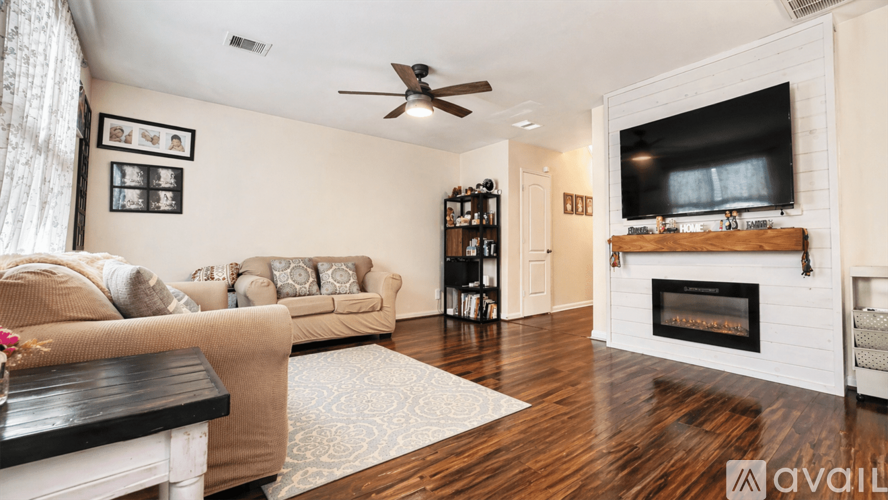A living room with a fireplace and a television on the wall.