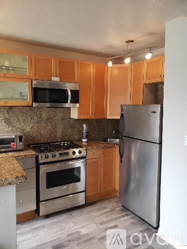 A kitchen with wooden cabinets and stainless steel appliances.