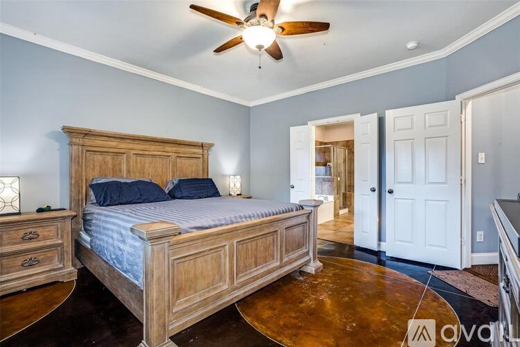 A bedroom with a bed, dresser, and ceiling fan.