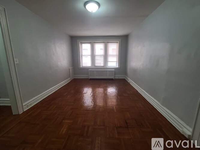 A room with wooden flooring and a window.