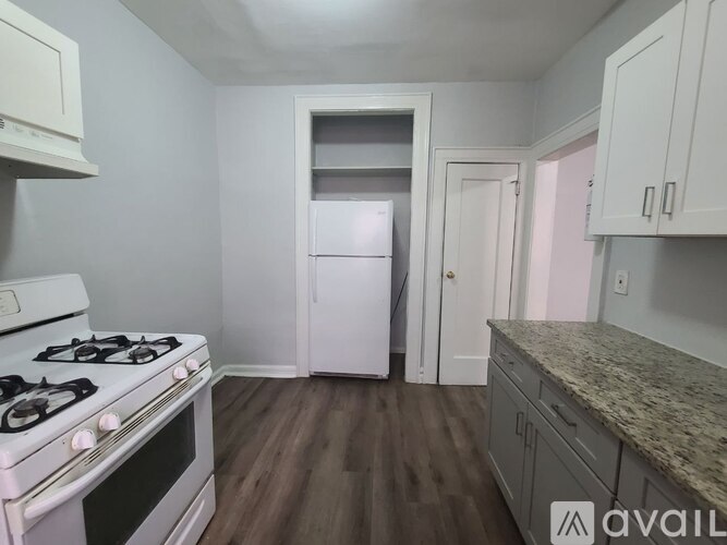 A kitchen with a white stove and a white refrigerator.
